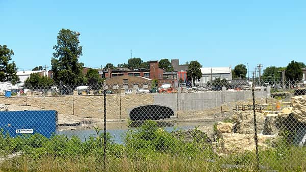 A municipal water treatment facility under construction with pipe sections and earthworks in the foreground