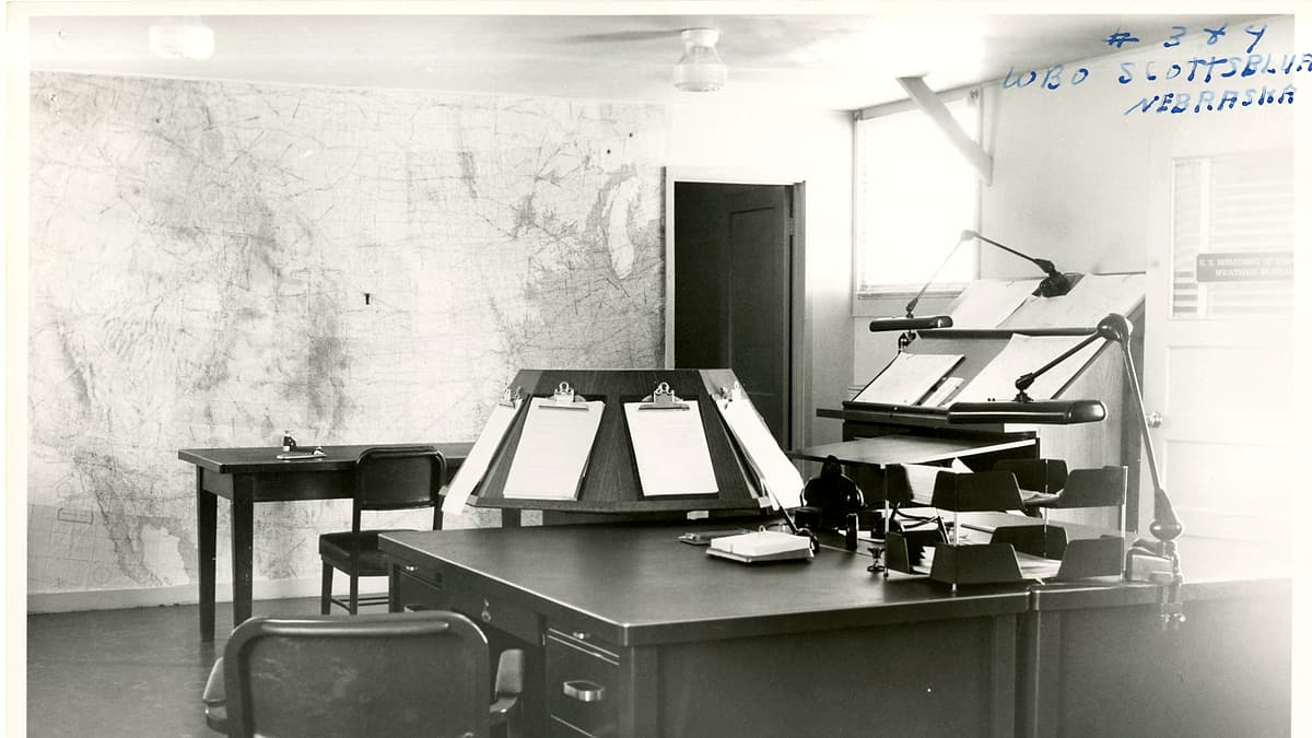 A typed letter on plain paper held flat by a metal ruler on a desk beside a capped pen